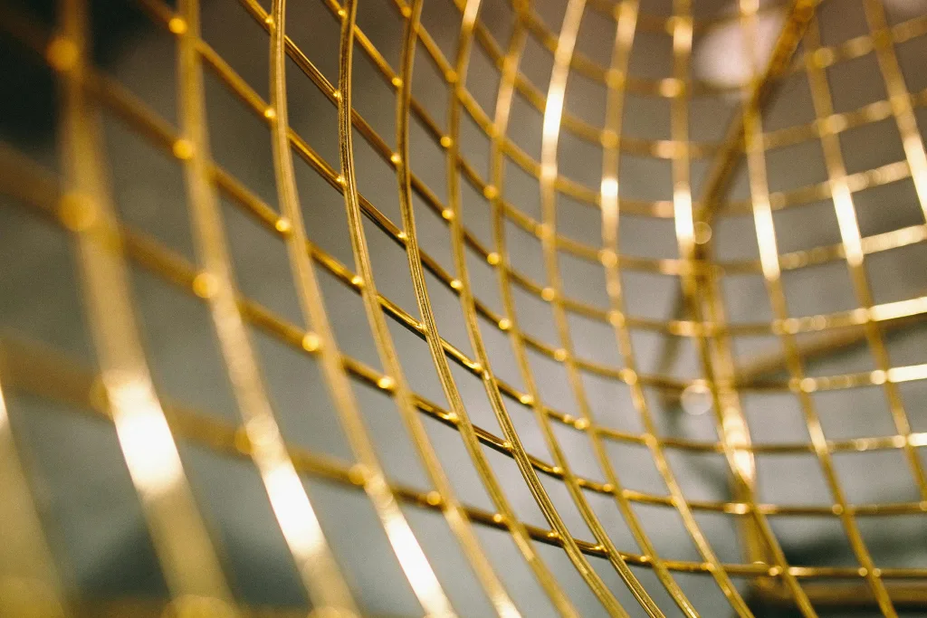 Close-up abstract of golden grid lines creating a modern artistic pattern, perfect for backgrounds.